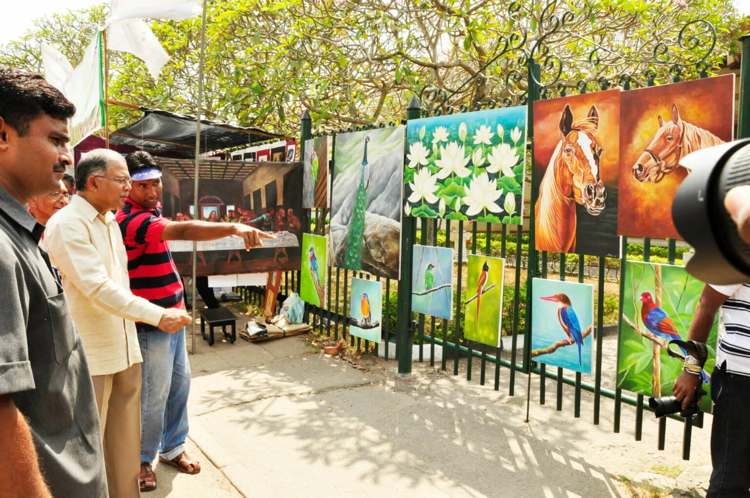 painting displayed on a fence, highlighting the artwork's details and colors.